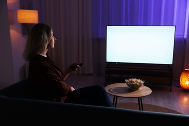 Photo of Woman watching tv at home in evening