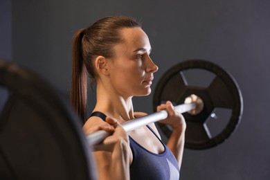 Photo of Sportswoman with barbell during crossfit workout in gym