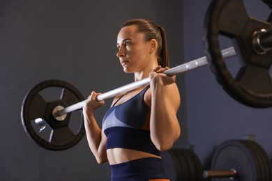 Photo of Sportswoman with barbell during crossfit workout in gym