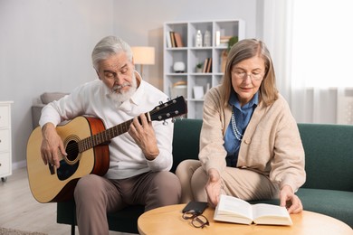 Photo of Cute elderly couple spending time together on sofa at home