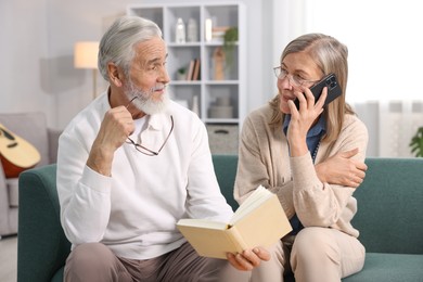 Photo of Cute elderly couple spending time together on sofa at home