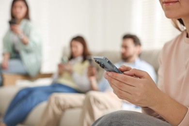 Photo of Internet addiction. Group of people with smartphones on sofa indoors, selective focus