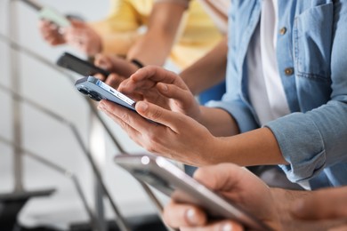 Photo of Internet addiction. Group of people with smartphones on stairs indoors, closeup