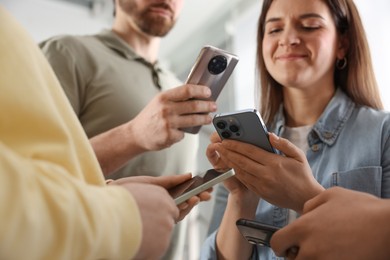 Photo of Internet addiction. Group of people with smartphones indoors, closeup