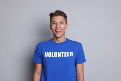 Photo of Portrait of smiling volunteer on grey background