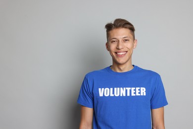 Photo of Portrait of smiling volunteer on grey background. Space for text