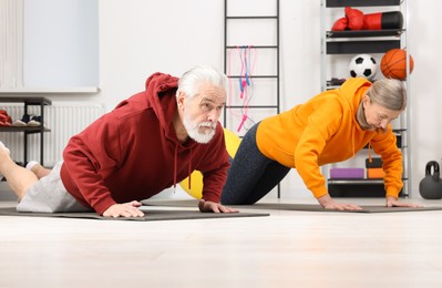 Photo of Elderly couple exercising at home. Healthy leisure