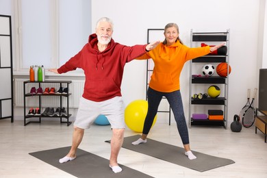 Photo of Elderly couple exercising at home. Healthy leisure