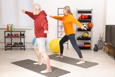 Photo of Elderly couple exercising at home. Healthy leisure