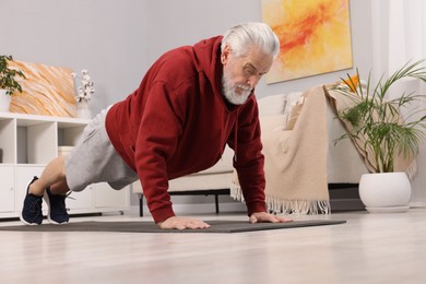 Photo of Elderly man exercising at home, low angle view