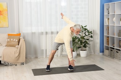 Photo of Elderly man exercising at home. Healthy leisure