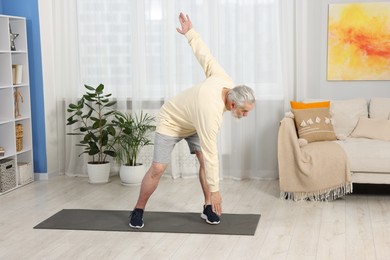 Photo of Elderly man exercising at home. Healthy leisure