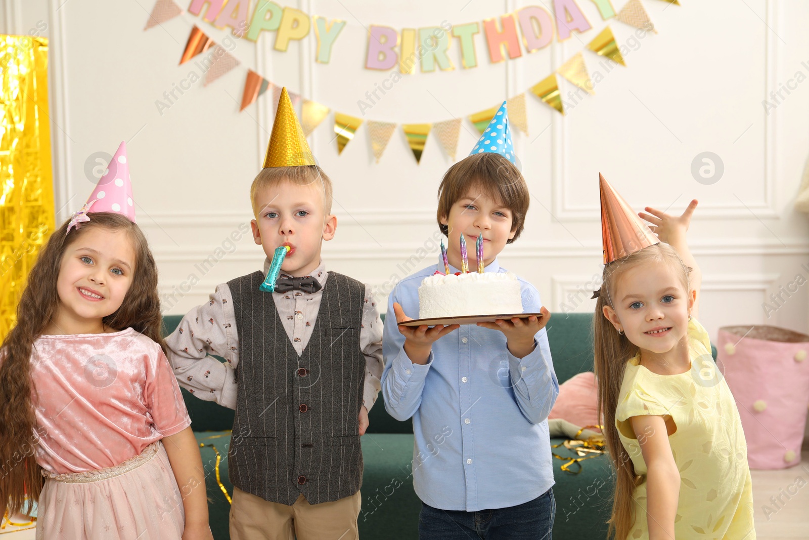 Photo of Children with tasty cake celebrating birthday indoors. Surprise party