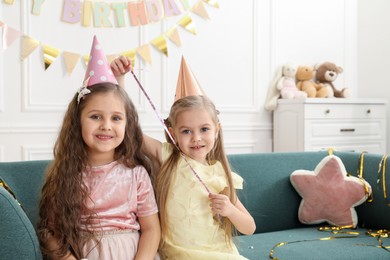 Photo of Children in conical paper hats indoors. Surprise party