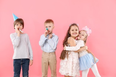 Photo of Children with blowers on pink background. Birthday surprise party