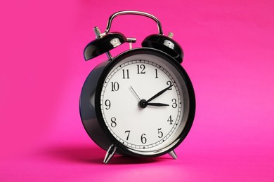 Photo of One black alarm clock on color background