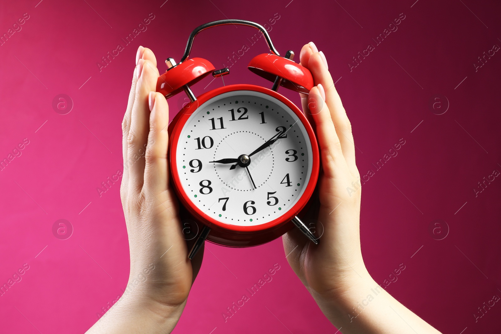 Woman with red alarm clock on bright pink background, closeup Photo of Woman with red alarm clock on bright pink background, closeup