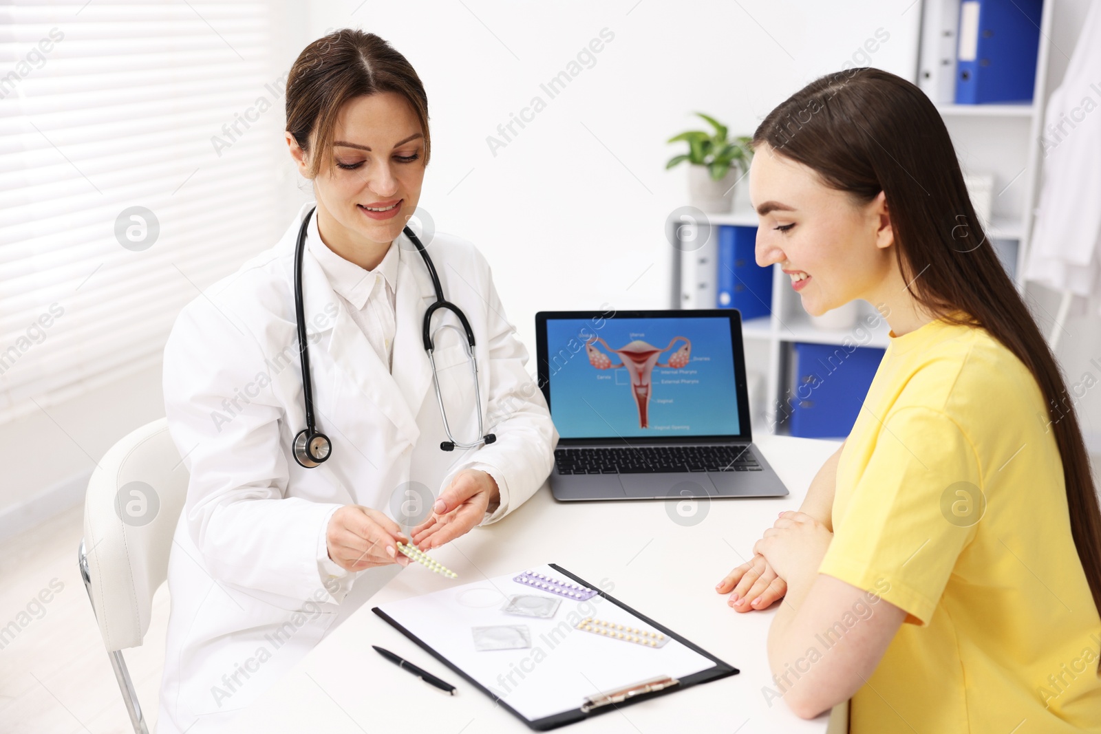 Photo of Gynecologist showing different contraceptive products to woman in clinic