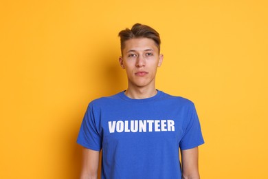 Photo of Portrait of young volunteer on orange background