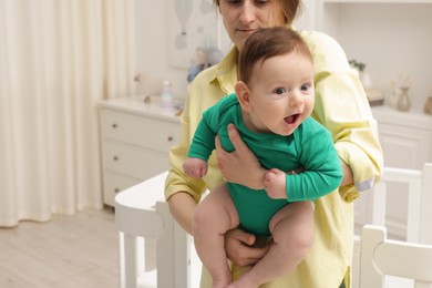 Photo of Mother holding her little baby at home, closeup