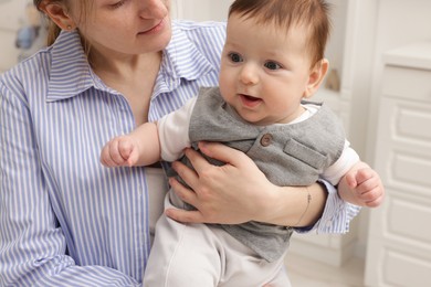 Photo of Mother holding her little baby at home, closeup