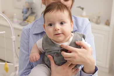 Photo of Mother holding her little baby at home, closeup