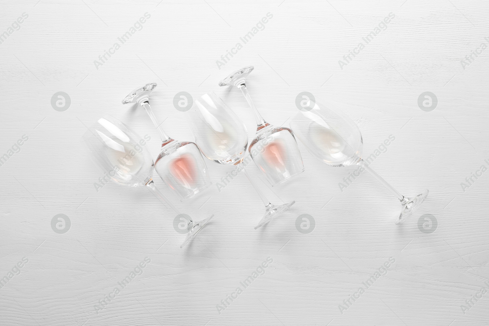 Wineglasses on white wooden table, flat lay Photo of Wineglasses on white wooden table, flat lay