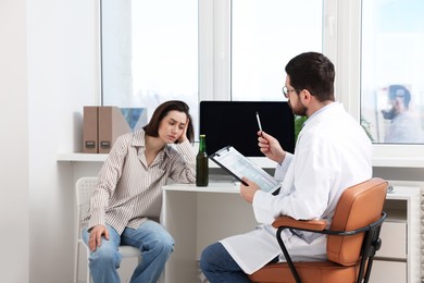 Photo of Alcoholic woman having appointment with healthcare specialist in clinic. Addiction treatment