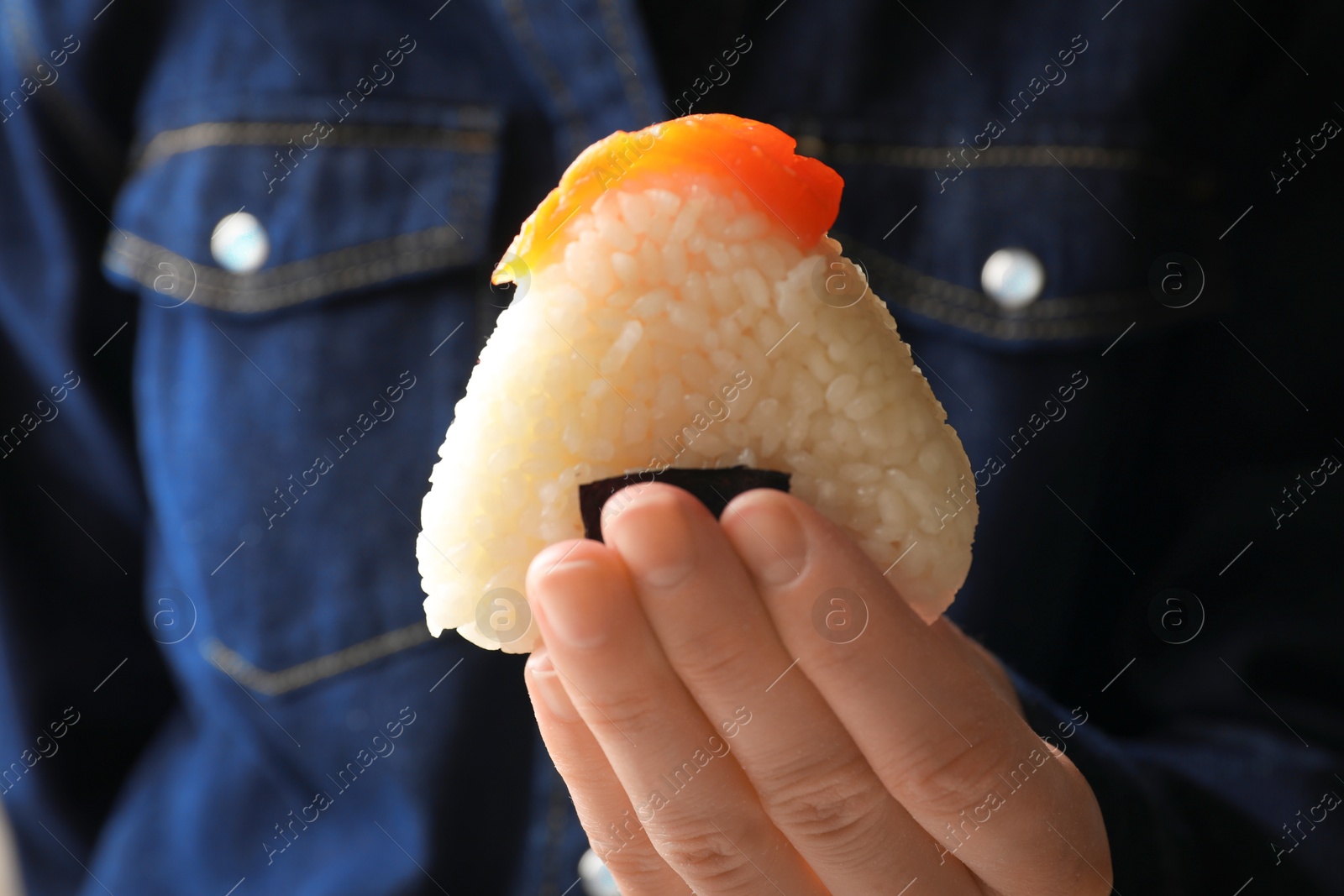 Woman with tasty onigiri (Japanese rice ball) indoors, closeup Photo of Woman with tasty onigiri (Japanese rice ball) indoors, closeup