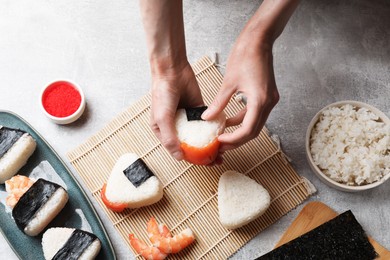 Photo of Woman making onigiri (Japanese rice balls) at light table, top view