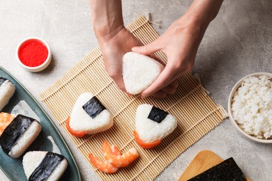 Photo of Woman making onigiri (Japanese rice balls) at light table, top view
