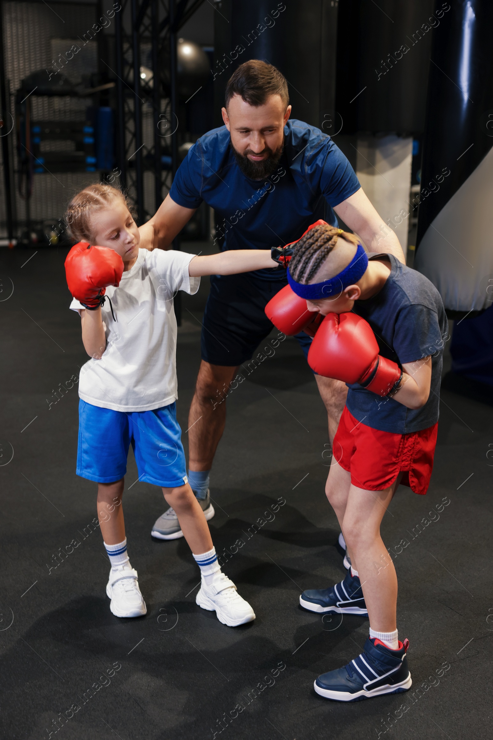 Photo of Boxing coach training children in sport center