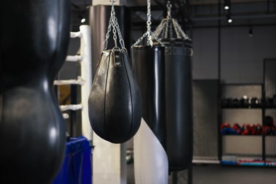 Photo of Punching bags near boxing ring indoors. Space for text