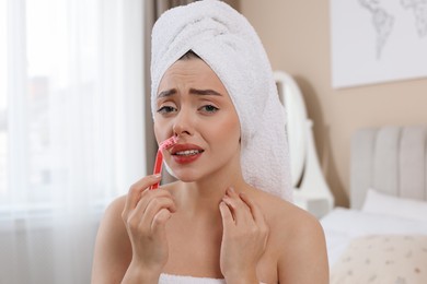 Photo of Emotional woman shaving her mustache with razor at home