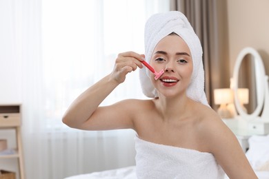 Photo of Happy woman shaving her mustache with razor at home