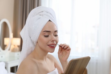 Photo of Happy woman plucking her mustache with tweezers at home