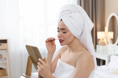 Photo of Beautiful woman plucking her mustache with tweezers at home