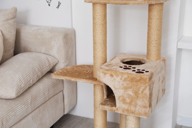 Photo of Stylish cat tree and sofa in living room