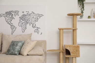 Photo of Stylish cat tree and sofa in living room