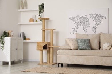 Photo of Stylish cat tree, chest of drawers and sofa in living room