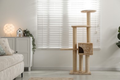 Photo of Stylish cat tree and chest of drawers in living room