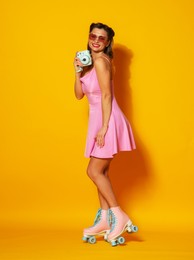 Photo of Happy woman with camera on orange background. Pin-up vibes