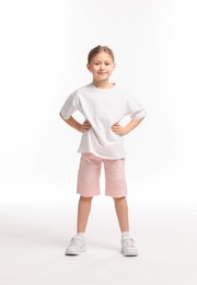 Photo of Cute little girl exercising on white background