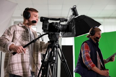 Photo of Men working with professional equipment in modern film studio