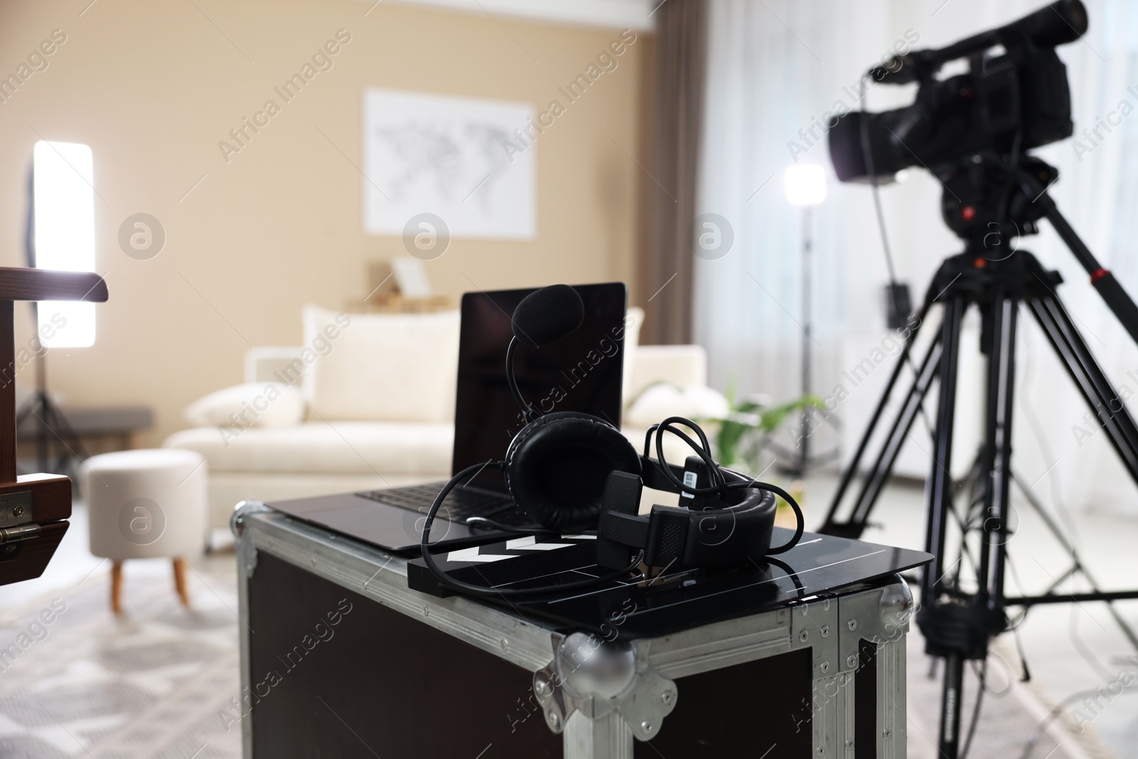 Photo of Headphones, camera, laptop and clapperboard in modern film studio, closeup