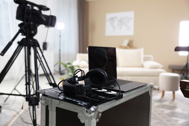 Photo of Headphones, camera, laptop and clapperboard in modern film studio, closeup