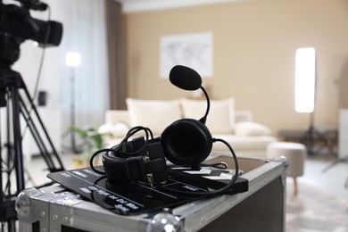 Photo of Headphones, camera and clapperboard in modern film studio, closeup