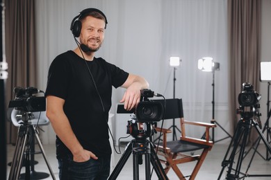 Photo of Cameraman with camera and headphones in film studio