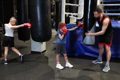 Photo of Children having boxing practice with their coach in training center