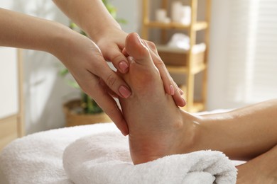 Photo of Woman receiving foot massage in spa salon, closeup